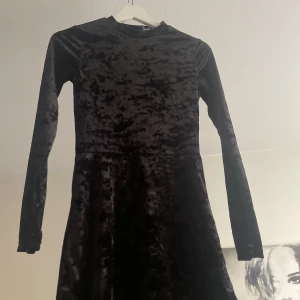 Svart sammetsklänning  - En svart sammetsklänning från H&M, lång i ärmarna och högre i halsen, sitter fint mot kroppen🖤 Säljer på grund av den inte används ofta, använd några fåtal gånger. Priset kan diskuteras vid snabb affär! 