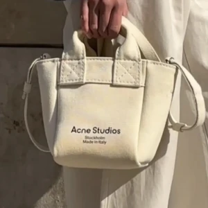 Acne Studios - Hej,   Jag säljer nu min Acne väska som är köpt på Jackie 2021. Kvitto finns och väskan är i bra skick men enstaka fläckar som går bort i tvätten.