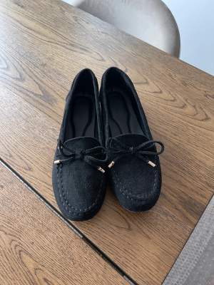 Nya och oanvända svarta loafers med guldiga detaljer i storlek 37. Oklart vilket märke det är. 100:- exkl porto. 