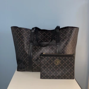 By Malene Birger väska  - By Malene Birger totebag i mycket gott skick använd fåtal gånger.  I paketet ingår även en kuvertväska/clutch i samma mönster i toppenskick. Ingår också en dustbag. Modellen är Trinolas-chokladbrun. Nypris 2800-3200kr och kuvertväskan är 900kr. 