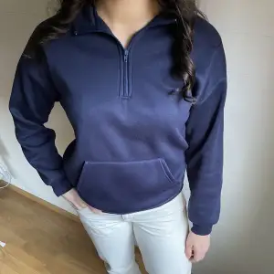 Marinblå sweatshirt med dragkedja, lite nopprig men annars i fint skick