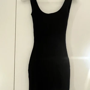 Svart klänning - Svart kort ribbad klänning men låg rygg