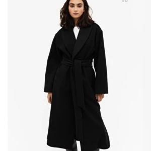 Kappa - En svart kappa från monki. Nypris 899kr. 