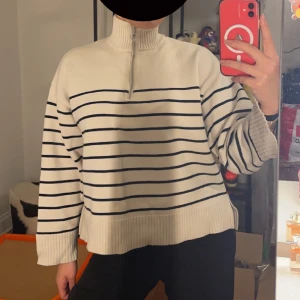 Stickad tröja - Stickad tröja i vetefärg med marinblå/svarta ränder från Zara. Halv zip. Säljer då den tyvärr aldrig kommer till användning längre. Skulle funka på Xs-M beroende på hur man vill den ska sitta. Jag bär vanligtvis M/S i tröjor.