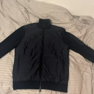 J Lindberg knitted hybrid jacka  - En J lindberg hybrid jacka i rätt så bra skick 8/10. Köpte den förra vintern men använde den inte så mycket och köpte nyss en ny jacka så därför säljer jag denna. Färg (navy blue)