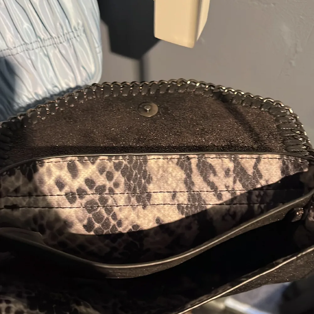 Svart handväska som jag tyvärr inte vet vart den är ifrån💞Den är väldigt nätt och enkel men glittrar väldigt fint. Den är i bra skick, men man kan se på den att den är lite använd! Inuti är den uppdelad i två fack. (19,5 x 12 cm). Väskor.
