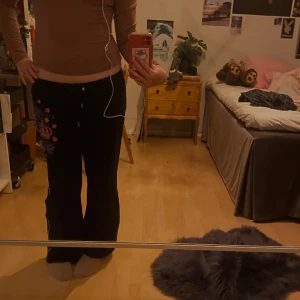 y2k mjukisbyxor  - Ett par jättefina lowrise y2k mjukisbyxor! Säljer då jag e lite trött på de, men dem är fortfarande i superbra skick. Några rhinestonestones har trillat av men annars inga defekter!💗  Innerbenslängd: 69cm Midjemått: 39cm