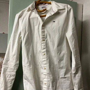 Tommy Hillfiger skjorta - Vit Tommy hilfiger skjorta.  I modellen ”slim fit”.  Endast använd en gång så jättefint skick.  Nypris ca. 600:-.  Skriv vid fler bilder eller intresse!