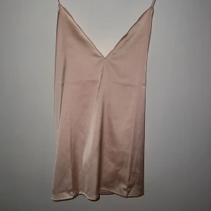 Satin linne  - Peach färgat linne jag aldrig använt. Öppen rygg med kryssad rygg. Storlek xl men skulle säga att det passar väldigt fint som både tajt och pösigt. 