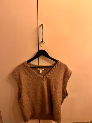 Stickad väst - Stickad väst som är i ett bomulls material, köpt från H&M. Aldrig använd och i fint skick. Lite oversized så skulle säkert passa en M eller L