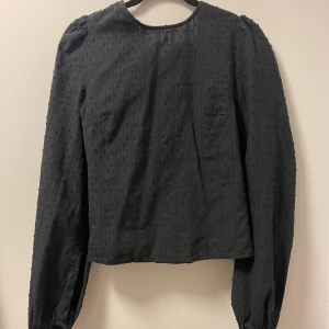 Blus med öppen rygg - Svart blus med öppen rygg.