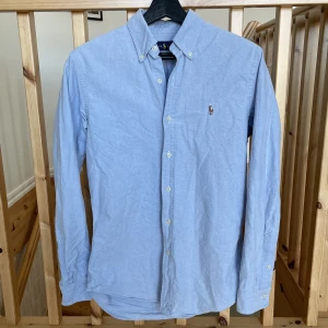 Ralph Lauren skjorta blå - Tja! Säljer nu min ljusblå skjorta från Ralph Lauren. Skick: 9/10. Storlek: S, custom fit. Nypris: 1200kr. Kontakta mig för fler bilder eller info!