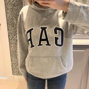 GAP HOODIE - En så snygg och väldigt populär hoodie från gap!!💞köptes för 300kr, den är i väldigt bra skick men nopprig, något som säkert går att ta bort!!💞 pris kan självklart diskuteras så lämna förslag💞