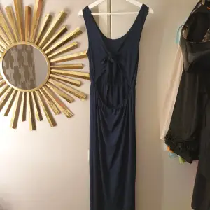 Marinblå maxi klänning med knyte i ryggen. Aldrig använts 