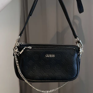 Guess väska - Helt ny guess väska. Det är som två väskor i en där den lilla går att lossa från den stora och användas som två separata väskor. Fick den i present men aldrig använt den. Nypris över 1000kr