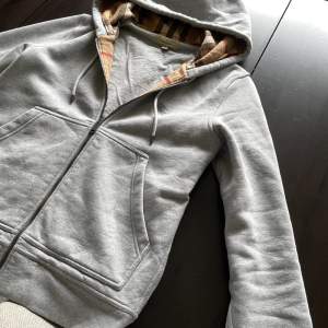 Snygg och eftertraktad Burberry hoodie i snygg grå färg, med Burberrys ikoniska mönster på insidan. Storlek S, passar även en M. Helt felfri och fräsh.  Vid frågor eller funderingar är det bara att höra av sig. 🙌