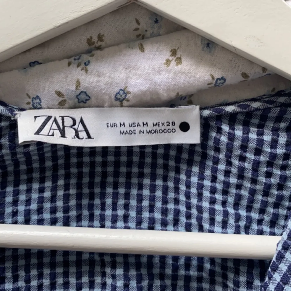 Blå och vit rutig blus från Zara med ballongärm och dragkedja vid sidan. Knappt använd i storlek M. Vringad med fina knappar. Super fin nu till sommaren🌸. Blusar.