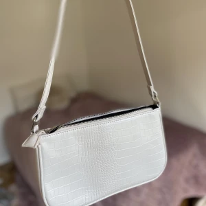 Vit handväska  - Vit handväska i fint skick! Har tre fack varav ett med dragkedja.