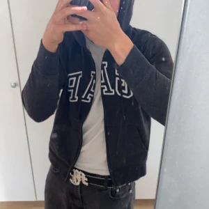 GAP zipup hoodie - Mörkgrå/svart GAP ziphoodie med text på. Den är i okej skick men är endå snygg.