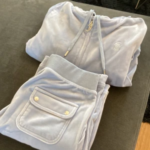 Juicy couture  - Säljer min juicy couture set i ljusblå använda 1 gång och är i nyskick skick!! Storlek S på både byxa och koftan. Nypris för båda är 2300:- säljer båda för 1000kr 
