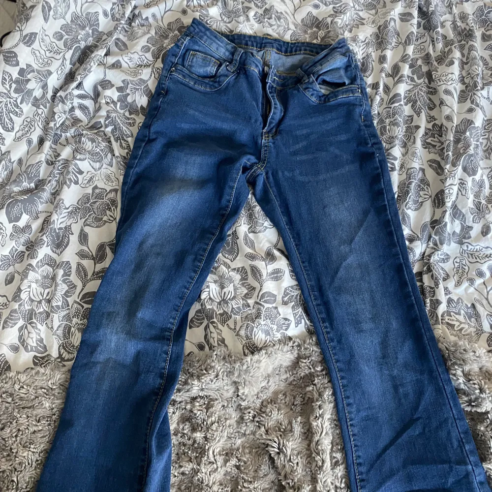 Låg midjade jeans en liten lös tråd längst ner på höger ben som går att klippa av . Jeans & Byxor.