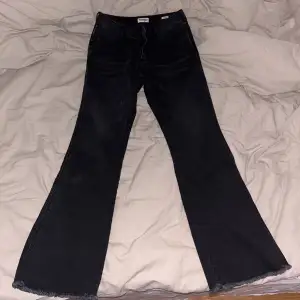 Ett par svarta Wrangler jeans i storlek 30x31. Lågmidjade och utsvängda ben. Använda endast en gång och är därför i ny-skick.