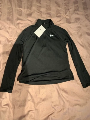 Nike - halfsip - Träningströja från Nike. Helt ny med lapp! M i barnstorlek, skulle gissa på att det motsvarar ungefär en XS i vuxen storlek. Säljes till förmånligt pris då den bara ligger och tar plats här hemma! 
