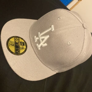 LA New era keps - Helt ny aldrig använt. Jätte fin design på sidan och är i perfekt skick. Storleken är S så om du har långt eller fluffigt så rekommenderar jag o inte köpa. Pris kan diskuteras. 