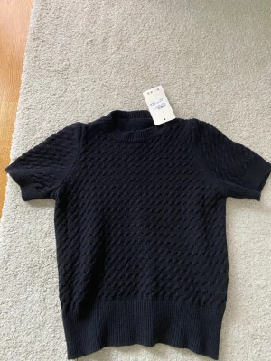 Stickad t-shirt - Säljer denna super snygga svarta stickade t-shirt. Helt ny med lappen kvar. Den är köpt på missäy i Göteborg. Storleken är i one size men skulle säga att de är en xs-s. Säljer då den inte kommer till användning.❤️❤️