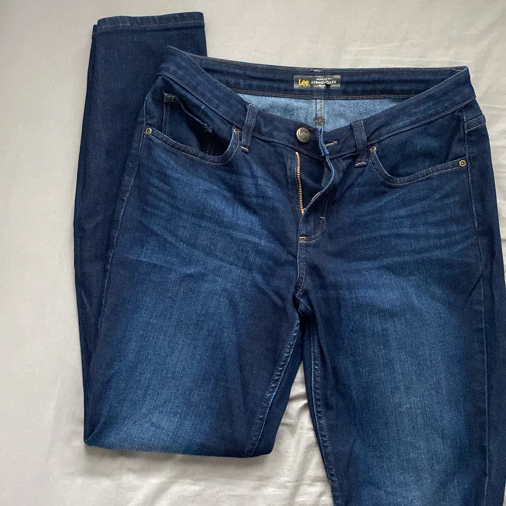 Mörkblåa jeans från Lee. Regular fit, straight leg och mid rise! Har tyvärr ingen bild med dessa på då det inte passat någon gång, så det är på tiden att bli av med dem! 😁Fått byxorna så är använda några gånger av annan användare!. Jeans & Byxor.