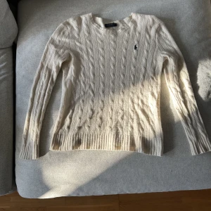 Stickad Ralph lauren tröja - Vit stickad tröja av märket Ralph lauren. Tröjan är i storlek m, tröjan är unisex så passar för alla. Tröjan är i bra skick.