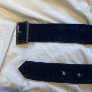 jeansskärp i 70tals stil - skitsnyggt skärp i jeansmaterial som inte kommer till användning då det inte matchar min stil. skriv för bilder hur der ser ut på. väldigt anpassningsbar storlek, skulle gissa från XS till L