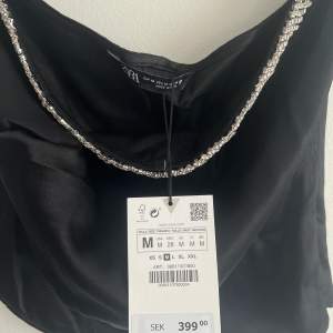 Never used bc it did not fit me, very pretty black satin tube top with a rhinestone detail obove the chest area