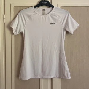 Vit stronger träningströja  - Säljer denna fina t-shirt från stronger då den är köpt i fel storlek och blev därav inte använd. Helt ny och inte använd. Nypris: 349kr (pris går alltid att diskuteras)