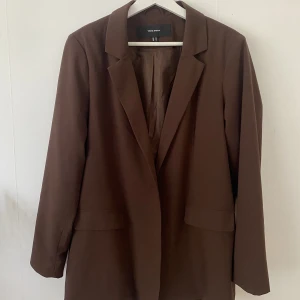 Vero Moda brun kavaj - Säljer en brun blazer från Veromoda i strl 42. Hämtas i Sundbyberg eller skickas mot fraktkostnad.