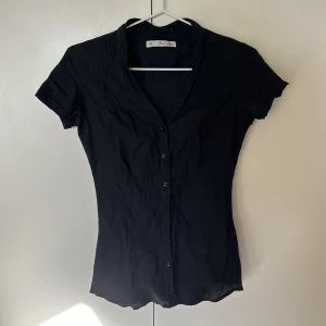 Svart kortärmad skjorta - Svart kortärmad skjorta köpt secound hand i storlek xs. Saknar två knappar, syns på tredje bilden. 🫶🏻🫶🏻