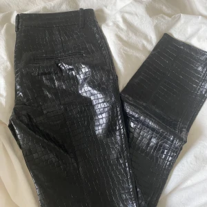 Skinnbyxor zara  - Skinnbyxor med ”snakeprint” från zara. Slits längst ner vilket är en fin detalj. Något långa på mig som är 160cm. En av dom ”skärpöglorna” har lossnat men går lätt att sy fast igen.