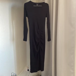 Klänning från NewYorker  - Långklänning med slits från NEW YORKER i storlek 38, köptes förra året men aldrig använd. Endast tvättad och testad! Nypris 219kr.