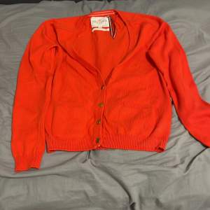 Jättefin röd-orange tröja men en knapp saknas men på andra bilden kan du se att den har en extra och den kan ni sy till på tröjan 