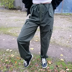 Gröna cargopants - Snygga cargopants i ett luftigt och lätt tyg som man enkelt kan röra sig i. De är inte använda mycket och har inga skador. (två riktiga fickor med knapp) 