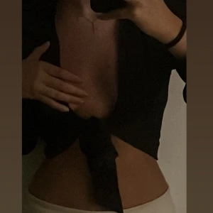 Satin kort topp med knytning  - Säljer denna från Linn Ahlborgs kollektion!! Säljer då den inte kommer till användning, den har knappar vid armarna längst ner så man kan knyta upp den, även skystera den med snörena 