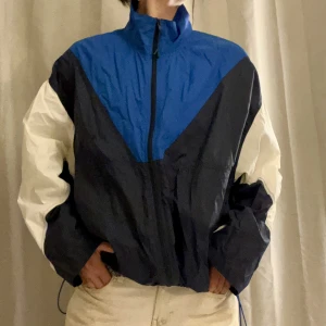 Tracksuit jacka - Tunn tracksuit-jacka/vindjacka med dragsko i midjan. Oversized så passar allt från XS-L. 