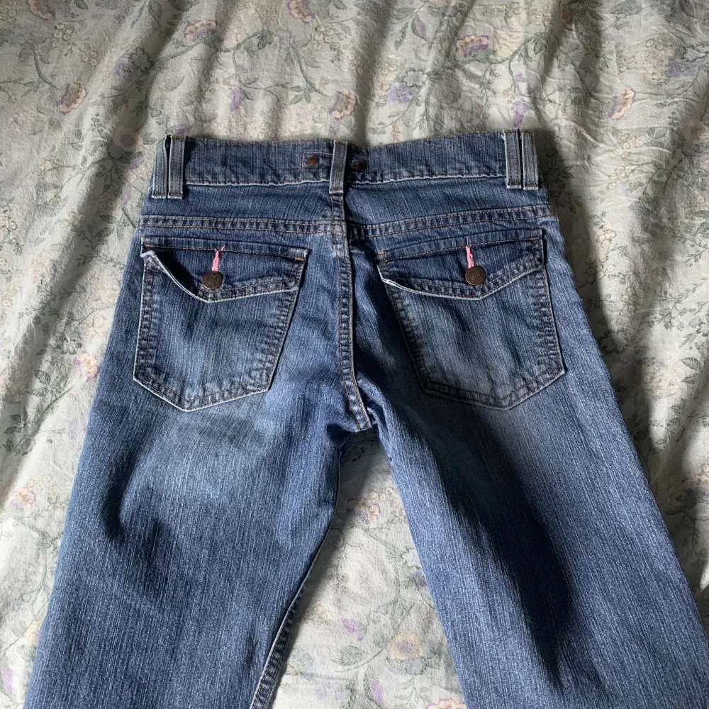 low waist jeans med knappar på fickorna bak . Jeans & Byxor.