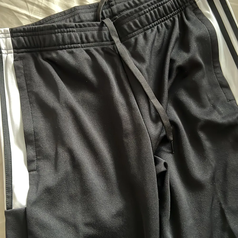Svarta adidas byxor med dragkedja på fickorna och längst ner på byxorna, köpta på intersport, aldrig använda  . Jeans & Byxor.