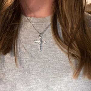 Kors halsband - Jättesnyggt silvrigt halsband som jag säljer då jag blivit mer av en guld människa, tyvärr kommer jag inte ihåg vart halsbandet är köpt då jag inte kan säga märket! Knappt använd och i bra skick! 