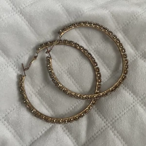 Örhängen hoop’s  - Fina stora ringar i guld med kristaller som skiner fint, minns ej vart dom köptes. Inga av kristallerna har åkt ut! 💛