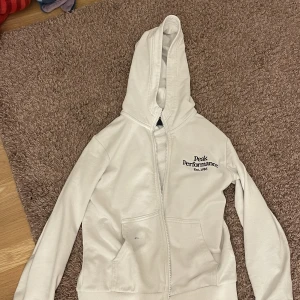 Peak performance kofta (äkta) - Koftan är äkta och är köpt från kidsbrandstore. Den är vit och storlek 140. Det är jättebra kvalite men det finns en blå fläck på fickan som inte vi har kunnat ta bort.