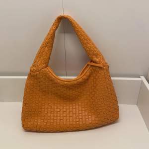 Botega inspirerad väska i orange, väldigt mycket utrymme i väskan!! Aldrig använd! 