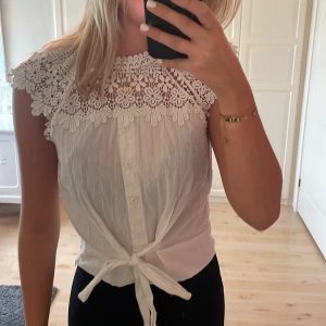T-shirt blus - En super söt somrig topp med blommor runt hals och axel partiet. Med en dragkedja vid sidan och knytning där fram🥰