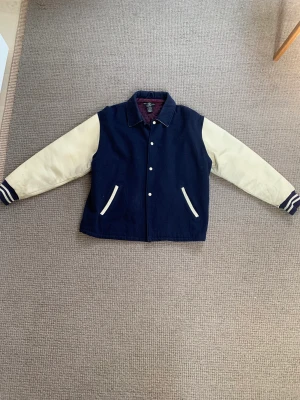 Vintage Varsity Jacka - Säljer nu min fina vintage jacka från warner bros studios.   Jackan har några år på nacken men håller fortfarande ett bra skick.  Mycket varsamt använd och inköpt i stockholm på no cricket fashion